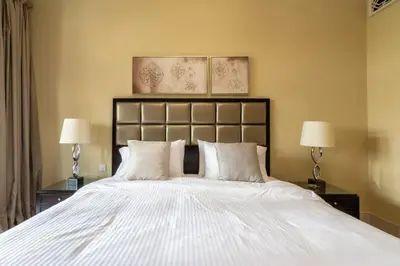 a bedroom with a large white bed with two lamps at Cozy 2BDR Residence in Dubai's Souk Al Bahar in Dubai