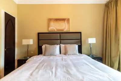 a bedroom with a large white bed with two lamps at Cozy 2BDR Residence in Dubai's Souk Al Bahar in Dubai