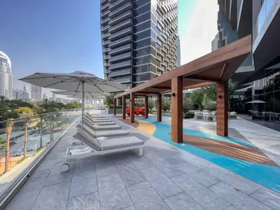 a patio with a table and an umbrella and a pool at Address Opera - Ultra luxurious 2BDR in Downtown in Dubai
