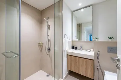 a bathroom with a shower and a sink and a mirror at Ultimate Luxury 3BDR With Burj Khalifa view in Dubai