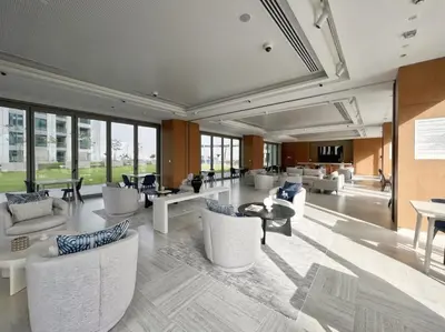 a large lobby with white chairs and tables and windows at Ultimate Luxury 3BDR With Burj Khalifa view in Dubai