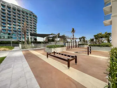 a park with benches in front of a building at LA VIE 1BDR in JBR with Private Beach in Dubai