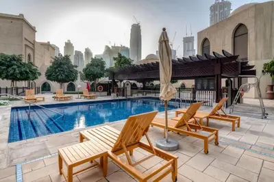 a swimming pool with two chairs and an umbrella at Gorgeous 1BDR with Burj Khalifa & Fountain Views in Dubai
