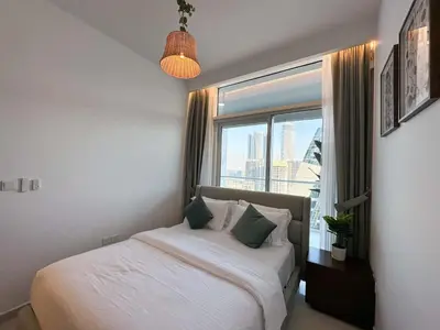 a bedroom with a bed and a large window at Brand new 1BDR in Vera- Business Bay in Dubai