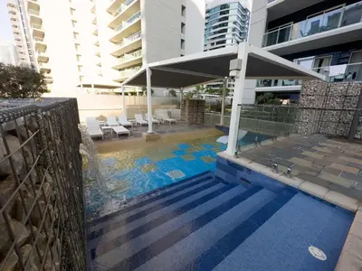 a swimming pool with a fountain in a building at Brand new 1BDR in Vera- Business Bay in Dubai