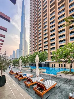 a swimming pool with chaise lounge chairs in front of buildings at Luxurious Studio Flat with Burj Khalifa Views in Dubai