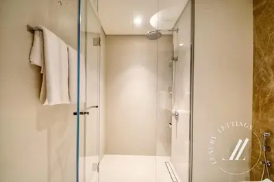 a shower with a glass door in a bathroom at Grand Bleu Tower 2 - 1 BDR with Beachfront Views in Dubai