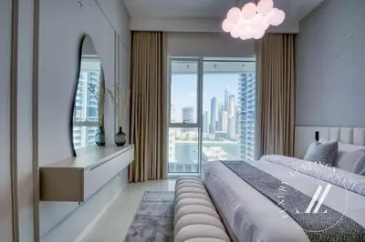 a bedroom with a large bed and a large window at Grand Bleu Tower 2 - 1 BDR with Beachfront Views in Dubai