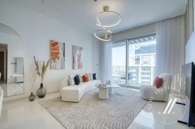 a living room with a white couch and a large window at Grand Bleu Tower 2 - 1 BDR with Beachfront Views in Dubai