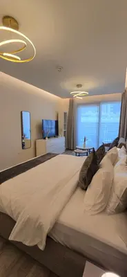 a large bedroom with a large bed and a flat screen tv at Studio Apartment Near downtown Dubai in Dubai