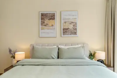 a bedroom with a bed with two pictures on the wall at Luxury 2 BR Spectacular Downtown and Sea View next to metro in Dubai