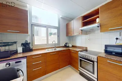 a kitchen with wooden cabinets and a sink at Cozy Studio in Dubai Marina in Dubai