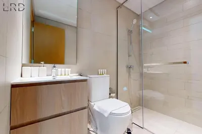a bathroom with a toilet and a glass shower at Modern 1BR with Canal View in Dubai