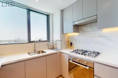 a kitchen with a sink and a stove and a window at Modern 1BR with Canal View in Dubai