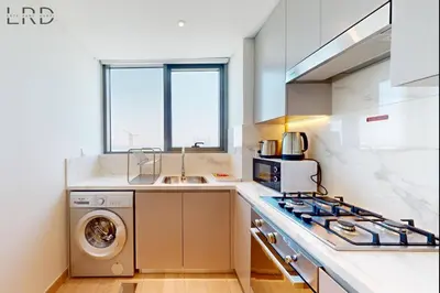 a kitchen with a washing machine and a sink at Charming 1BR with Canal View in Dubai
