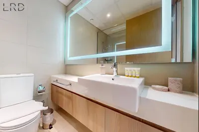 a bathroom with a white sink and a mirror at Charming 1BR with Canal View in Dubai