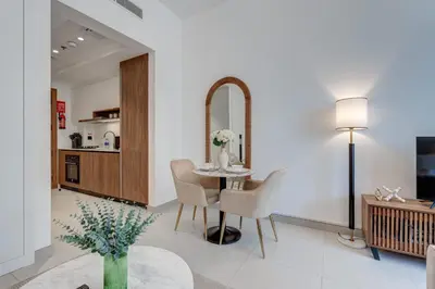a living room with a table and chairs and a mirror at PVH - Contemporary Studio - Prime Residency 3 in Dubai
