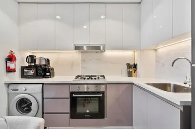 a kitchen with white cabinets and a dishwasher at PVH - Chic 1BR in Azizi Riviera 37 in Dubai