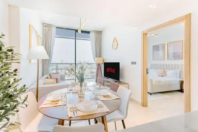 a dining room and living room with a table and chairs at PVH - Vibrant 1BR - Binghatti Corner in Dubai
