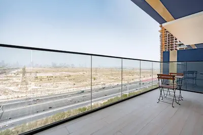 a balcony with a desk and a view of a highway at PVH - Vibrant 1BR - Binghatti Corner in Dubai