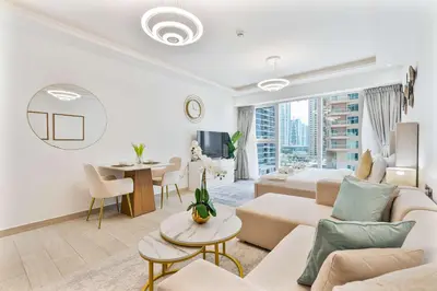 a living room with a couch and a bed and a table at PVH - Chic Furnished Studio in JLT - Me Do Re in Dubai