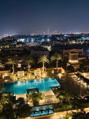 a view of a swimming pool at night at Rahaal 1 BDR, Madinat Jumeirah in Dubai