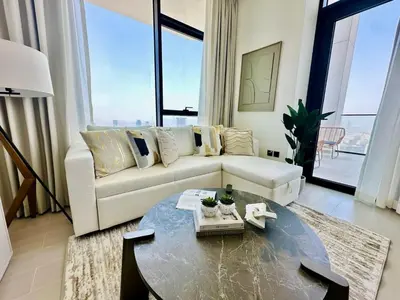 a living room with a white couch and a table at Sky 2br Sanctuary With Plunge Pool Gym Parking! in Dubai
