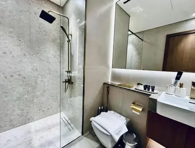 a bathroom with a shower and a toilet and a sink at Sky 2br Sanctuary With Plunge Pool Gym Parking! in Dubai
