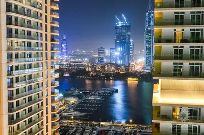 a view of a city at night with tall buildings at Luxury 2 Bedroom Apartment - Private Beach - Emaar Beach Vista in Dubai