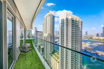 a balcony with a chair and a view of the city at Luxury 2 Bedroom Apartment - Private Beach - Emaar Beach Vista in Dubai