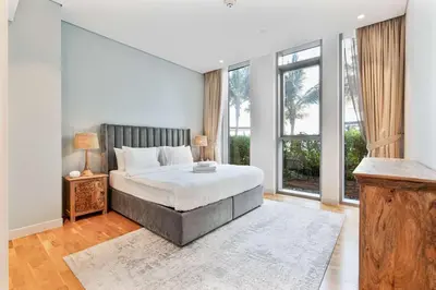 a bedroom with a bed and a large window at PVH - Tranquil 2BR - Bluewaters Residences 5 in Dubai