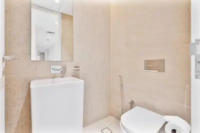 a bathroom with a white toilet and a mirror at PVH - Tranquil 2BR - Bluewaters Residences 5 in Dubai
