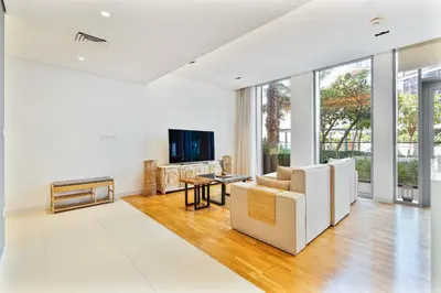 a living room with a white couch and a tv at PVH - Tranquil 2BR - Bluewaters Residences 5 in Dubai