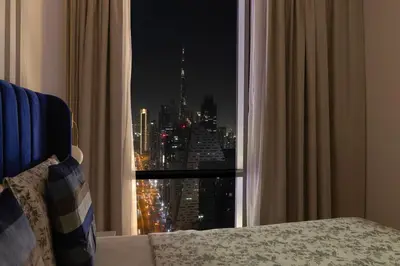 a bedroom with a window with a view of a city at Luxury 4BHK in Business Bay w Burj Khalifa View Noora 4203 in Dubai