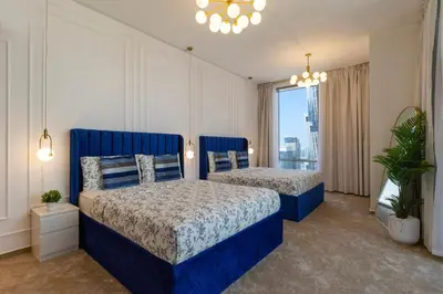 a bedroom with two beds and a large window at Luxury 4BHK in Business Bay w Burj Khalifa View Noora 4203 in Dubai