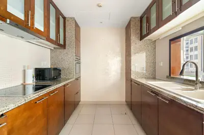 a large kitchen with a sink and a microwave at Silkhaus Luxurious 1BDR in Downtown in Dubai