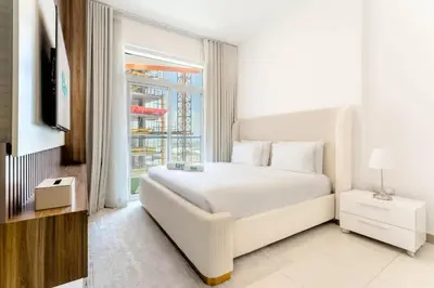 a white bedroom with a white bed and a window at FAM Living 1BR Stay Binghatti Gateway, Al Jaddaf in Dubai
