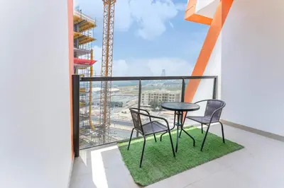 a balcony with a table and chairs and a crane at FAM Living 1BR Stay Binghatti Gateway, Al Jaddaf in Dubai