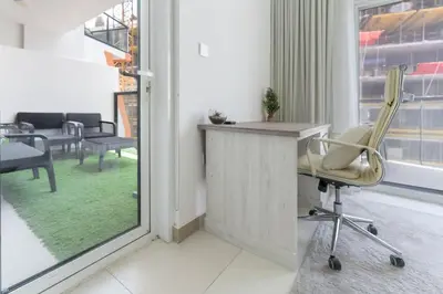a office with a chair and a desk and a window at FAM Living 1BR Stay Binghatti Gateway, Al Jaddaf in Dubai