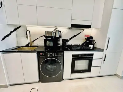 a kitchen with a stove and a washing machine at Serene Canalfront Studio Apt With Private Jacuzzi! in Dubai