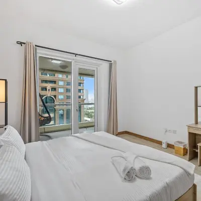 a bedroom with a white bed with a window at 1BR in Sulafa Tower- Ideal for Short-Term Stay in Dubai