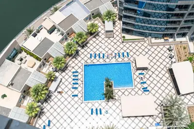 an overhead view of a pool with palm trees and a building at Stylish Studio with Spacious Balcony Walk to JBR Beach in Dubai