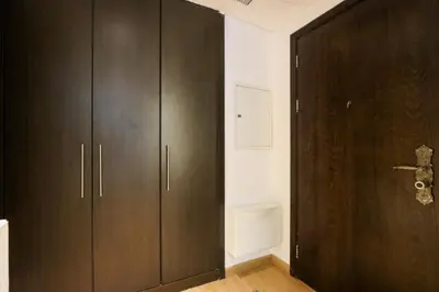 a dark wooden cabinet in a room with a door at Stylish Studio with Spacious Balcony Walk to JBR Beach in Dubai
