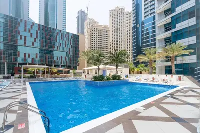 a swimming pool in the middle of a city with tall buildings at Stylish Studio with Spacious Balcony Walk to JBR Beach in Dubai