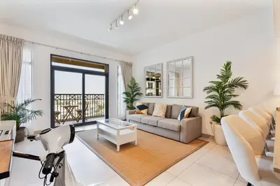 a living room with a couch and a table at Serene 1BR Stay with Pool, Gym, & Kids Playground in Dubai