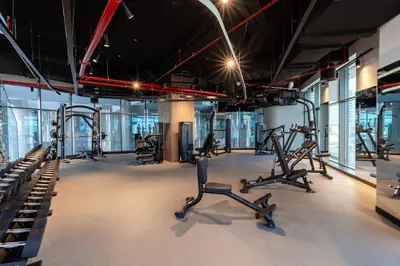a gym with several treadmills and elliptical machines at Waves - Impressive 1BR Apartment Close to Burj Khalifa in Dubai