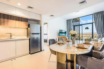 a kitchen and dining room with a table in a kitchen at Luxury 1BR Hills Green View Mall & Downtown Dining Shopping in Dubai