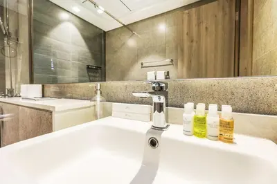 a bathroom with a sink with two bottles on it at Luxury 1BR Hills Green View Mall & Downtown Dining Shopping in Dubai