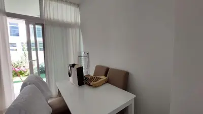 a living room with a couch and a table with a tv at Damac hills 2 vardon cluster in Dubai