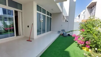 an empty courtyard of a building with green grass and flowers at Damac hills 2 vardon cluster in Dubai